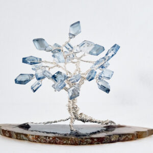 2.5" wired tree with silver colored wire and kite shaped clear light blue glass beads on a slice of earth tone agate