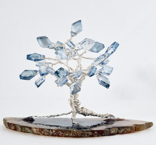 Ice Diamond Small Tree 2.5" wired tree with silver colored wire and kite shaped clear light blue glass beads on a slice of earth tone agate